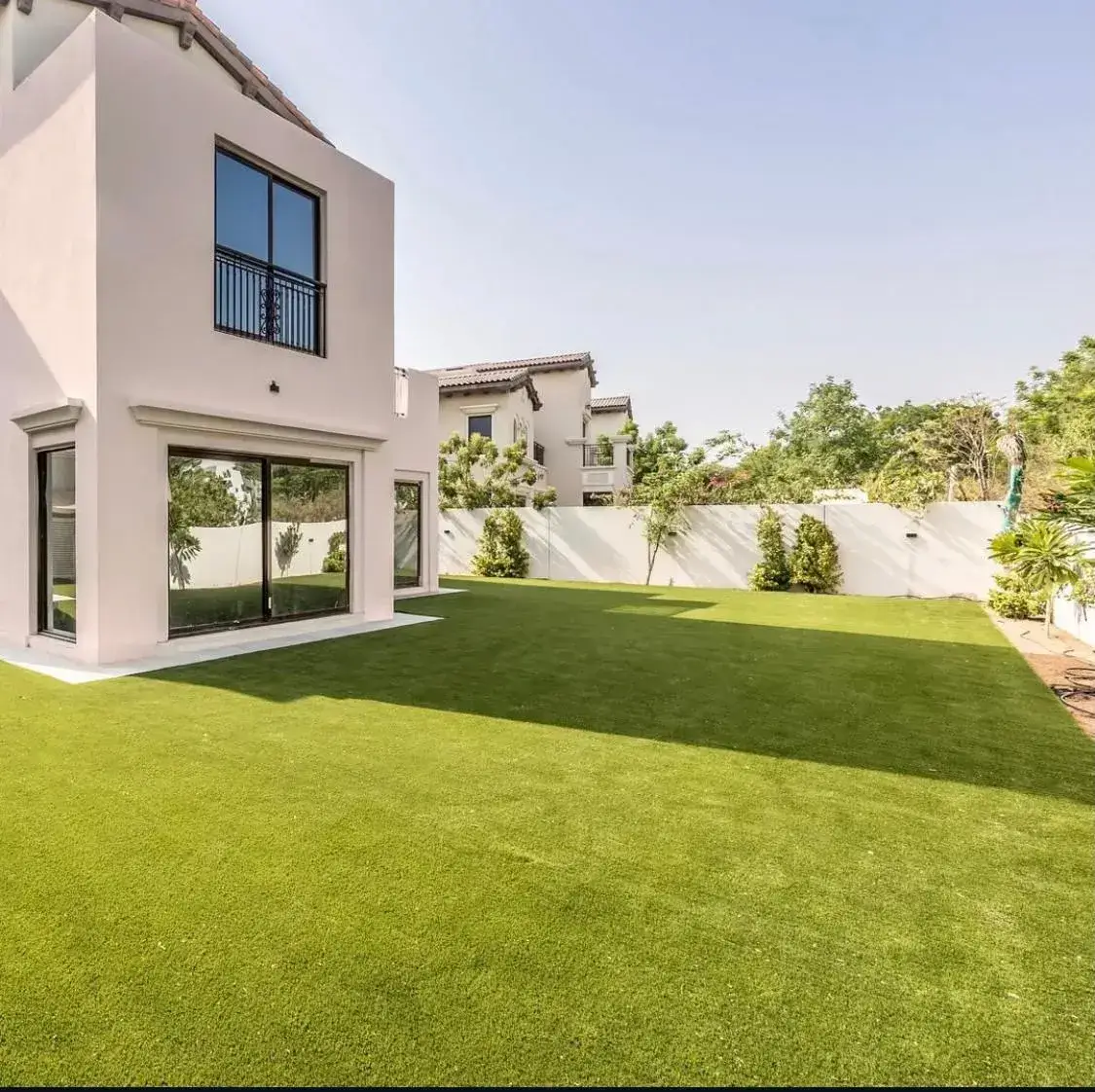 Contemporary villa garden in Dubai featuring a clean artificial lawn and minimalist exterior. Designed by Reshape Landscaping and Design, a British-owned landscaping company in Dubai specialising in modern outdoor spaces and low-maintenance garden solutions.