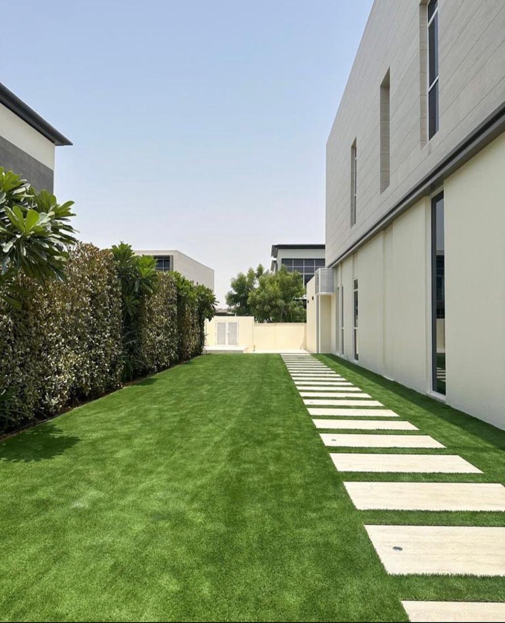 Luxury garden landscaping with artificial grass and stepping stone pathway at a Dubai villa by Reshape Landscaping