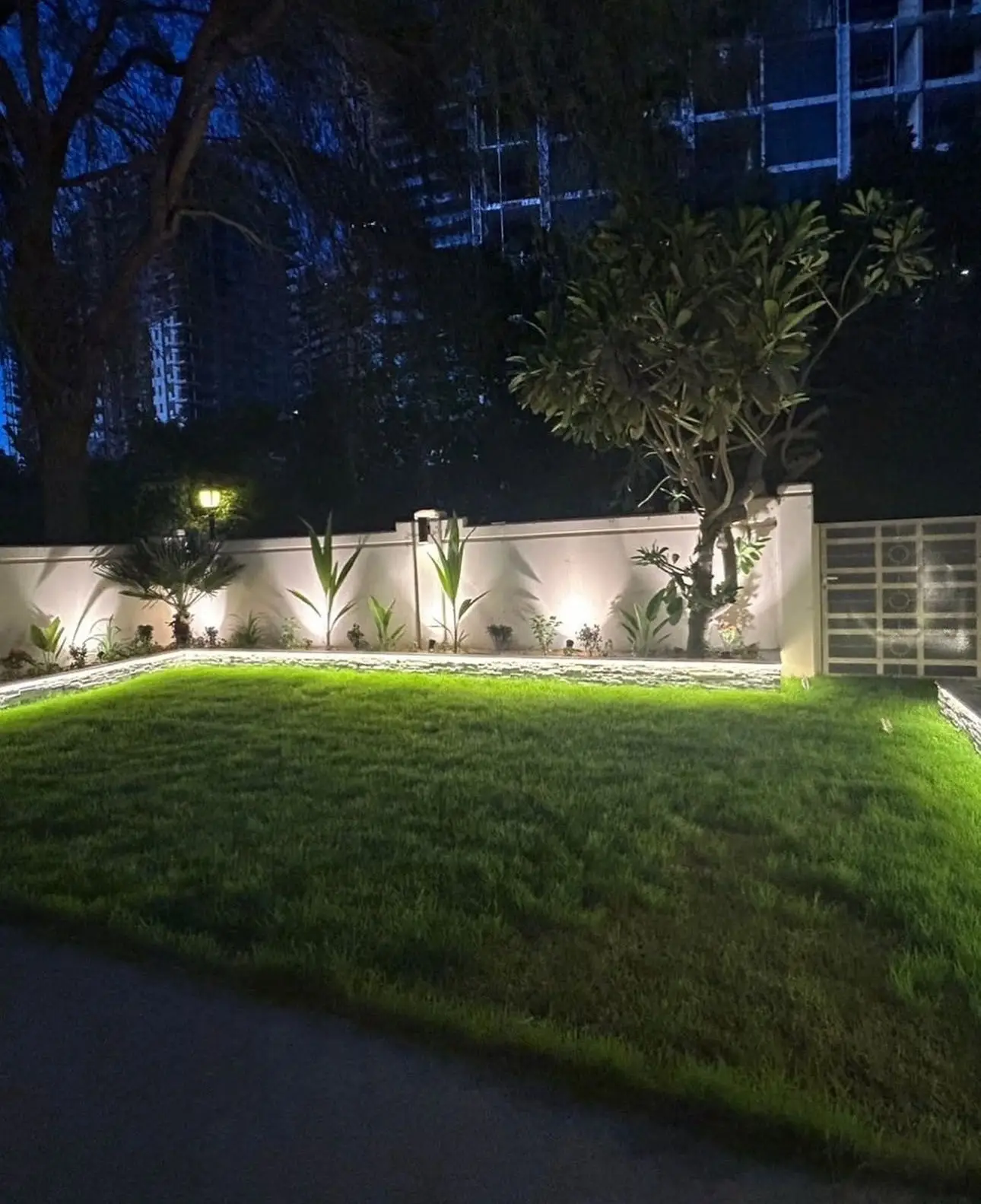 Garden lighting installation in Dubai villa with illuminated planting and lawn landscaping at night