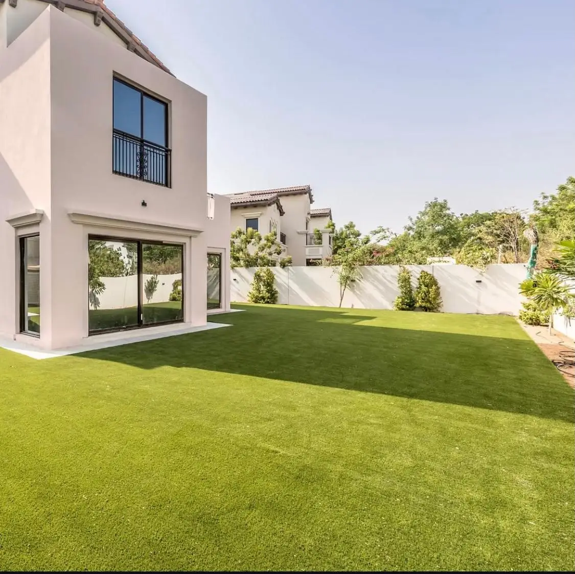 Artificial grass installation in Dubai villa garden with full lawn landscaping and low maintenance design